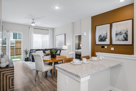 a living room and dining room with a table and chairs
